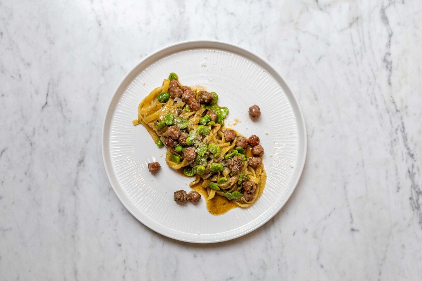 Plated fettuccine with fava beans and pecorino
