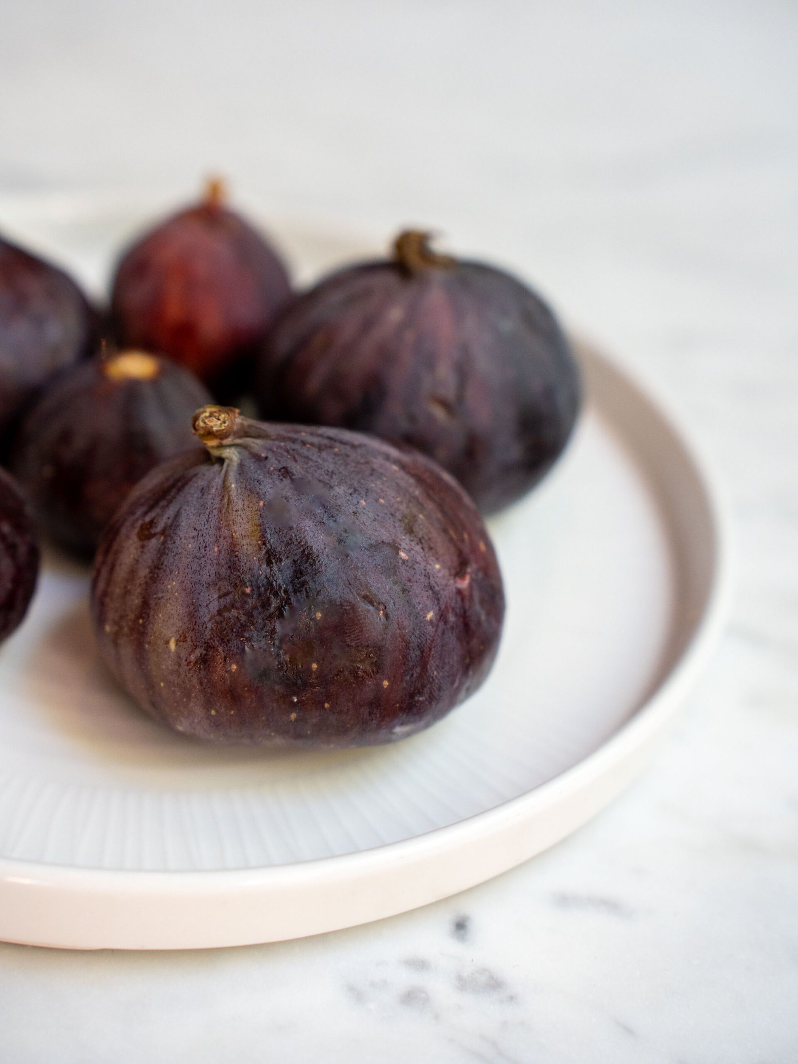 Fichi neri salentini interi su un piatto di ceramica chiara