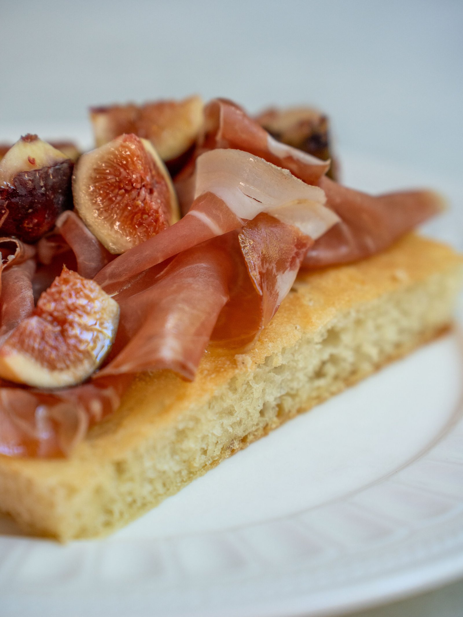 Trancio di pizza in teglia con prosciutto crudo di Bassiano e spicchi di fichi neri salentini